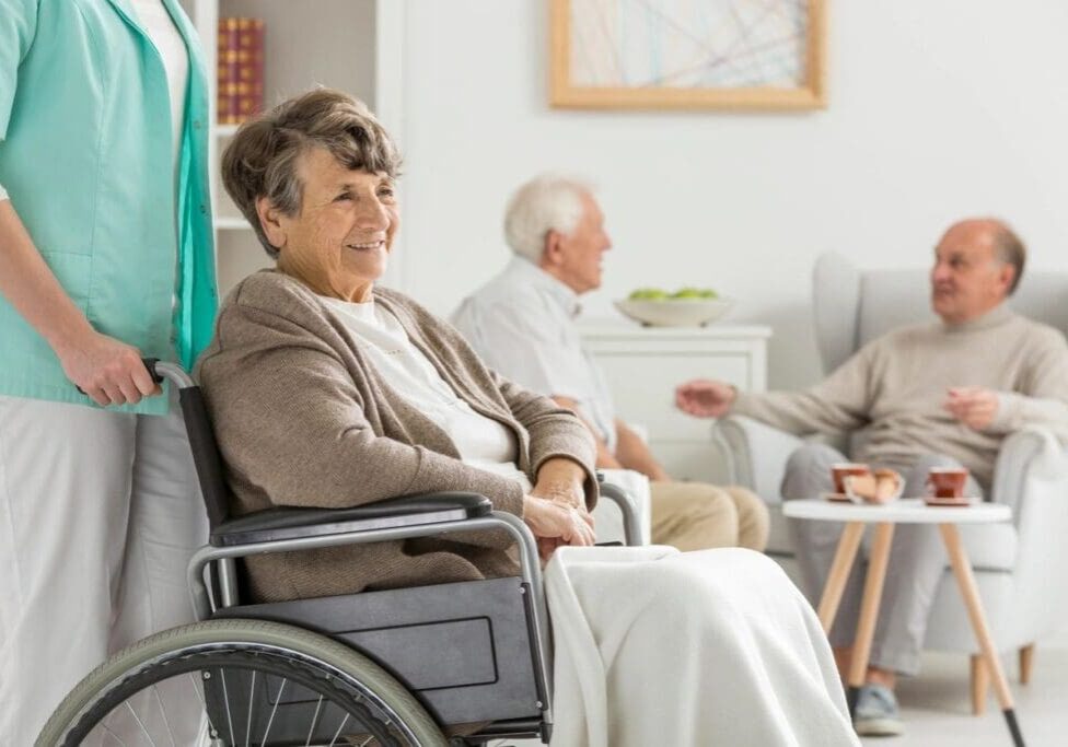 A woman in a wheelchair is sitting next to two other people.