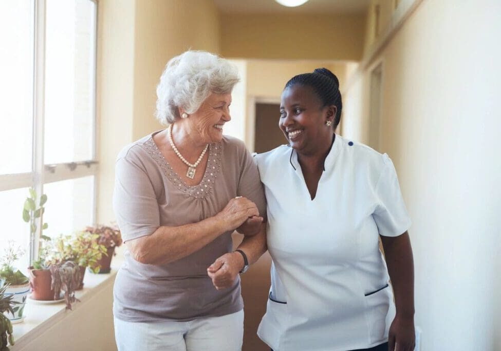 Two women are walking together in a hallway.